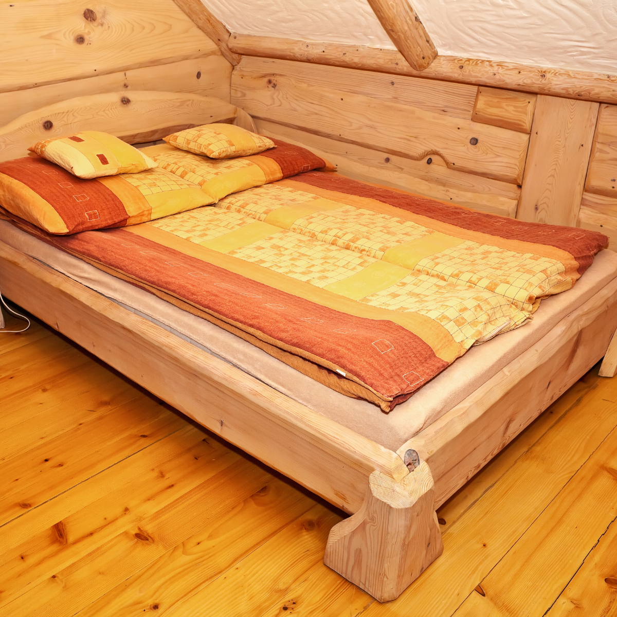 A minimalist wooden bed frame in a modern bedroom setting with neutral colors.